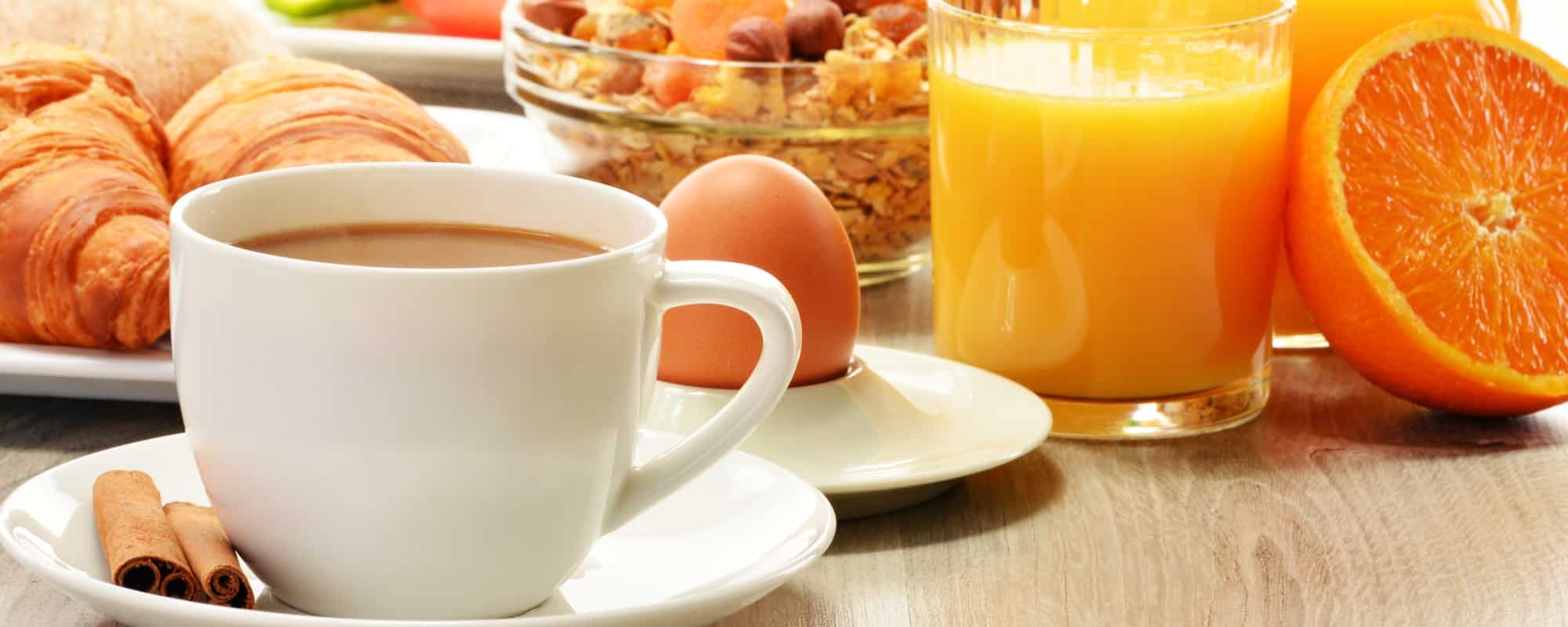 Breakfast with coffee, orange juice, croissant, egg, vegetables and fruits Breakfast with coffee, orange juice, croissant, egg, vegetables and fruits